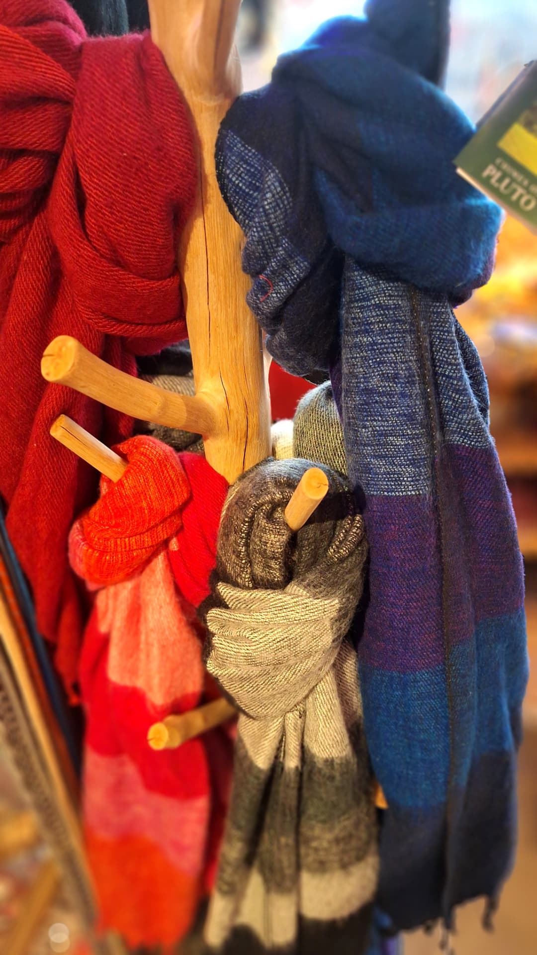 Écharpes en laine rouges et bleues sur un porte-manteau en bois chez Luxiol