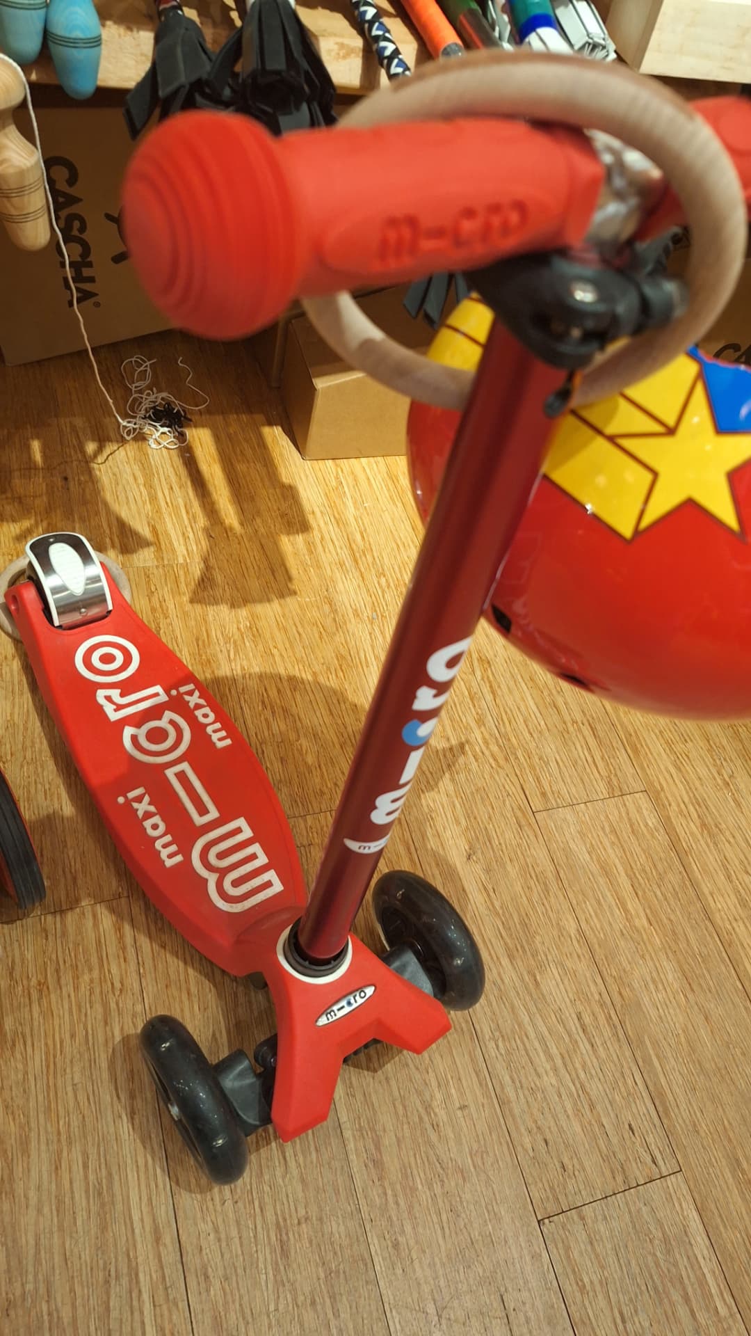 Trottinette Micro Maxi rouge posée dans la boutique Luxiol