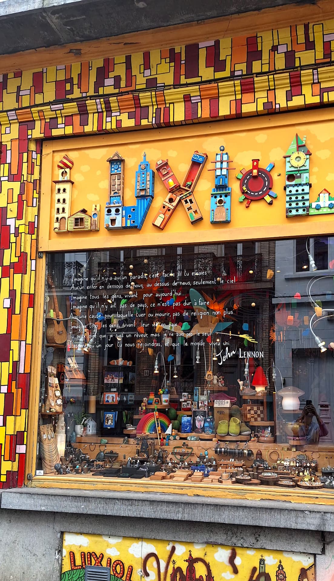 Façade de la boutique Luxiol avec enseigne en bois et texte de John Lennon