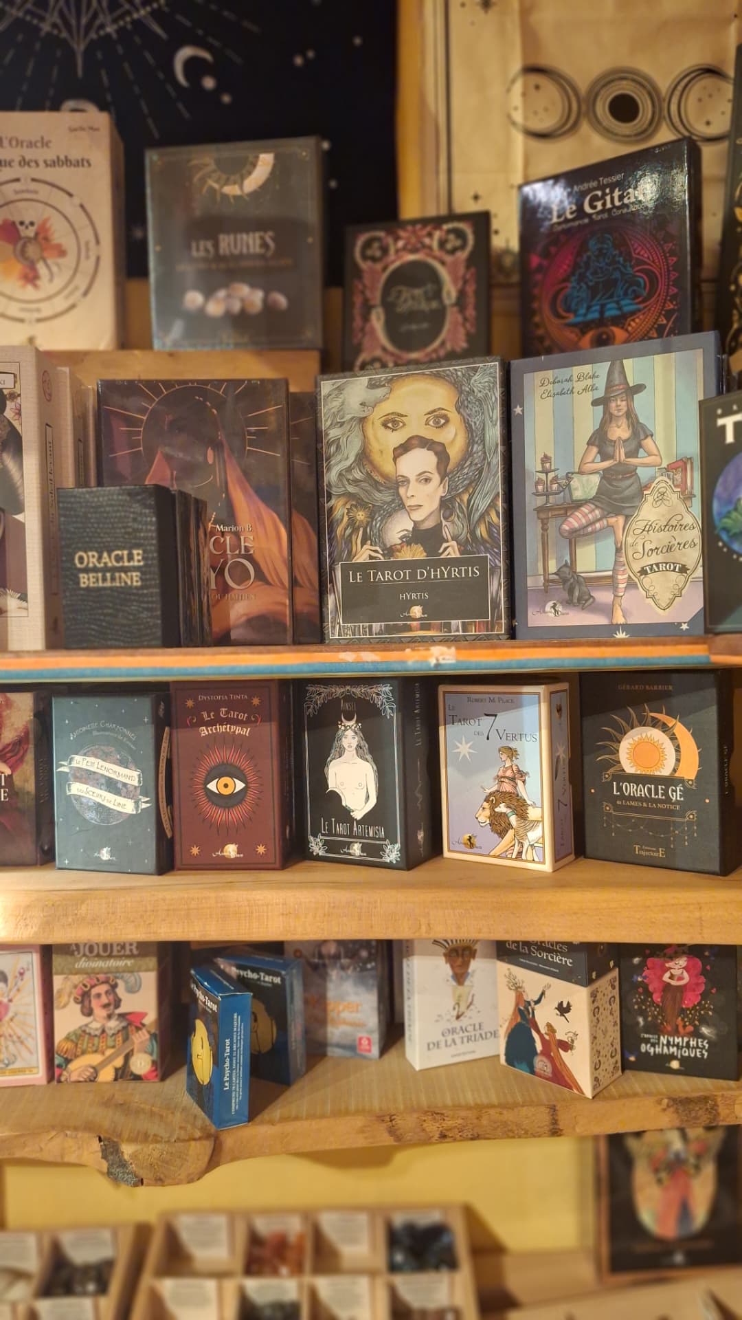 Tarots illustrés, runes et oracles présentés en vitrine chez Luxiol
