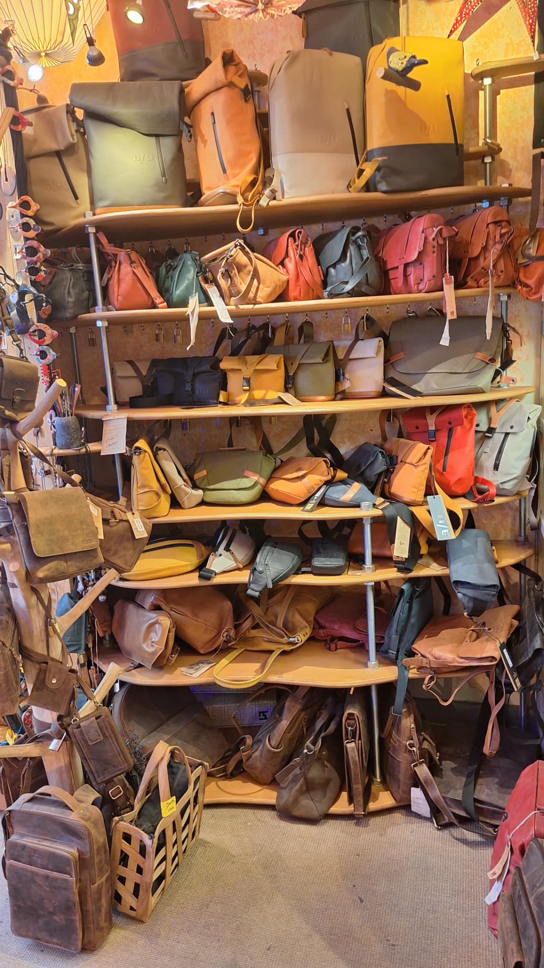 Mur d'étagères rempli de sacs et sacs à dos colorés chez Luxiol