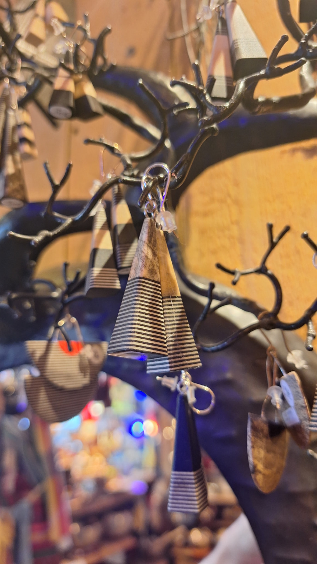 Détail de boucles d'oreilles coniques en bois marqueté chez Luxiol