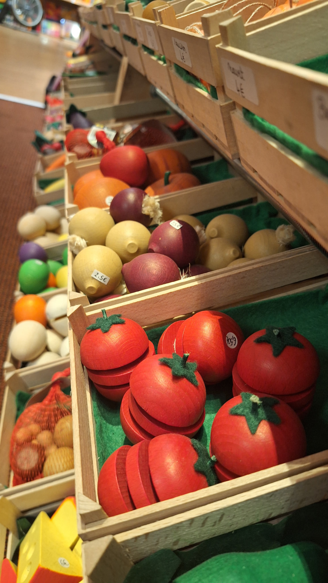 Rangée de cagettes de tomates, citrons et oignons en bois chez Luxiol