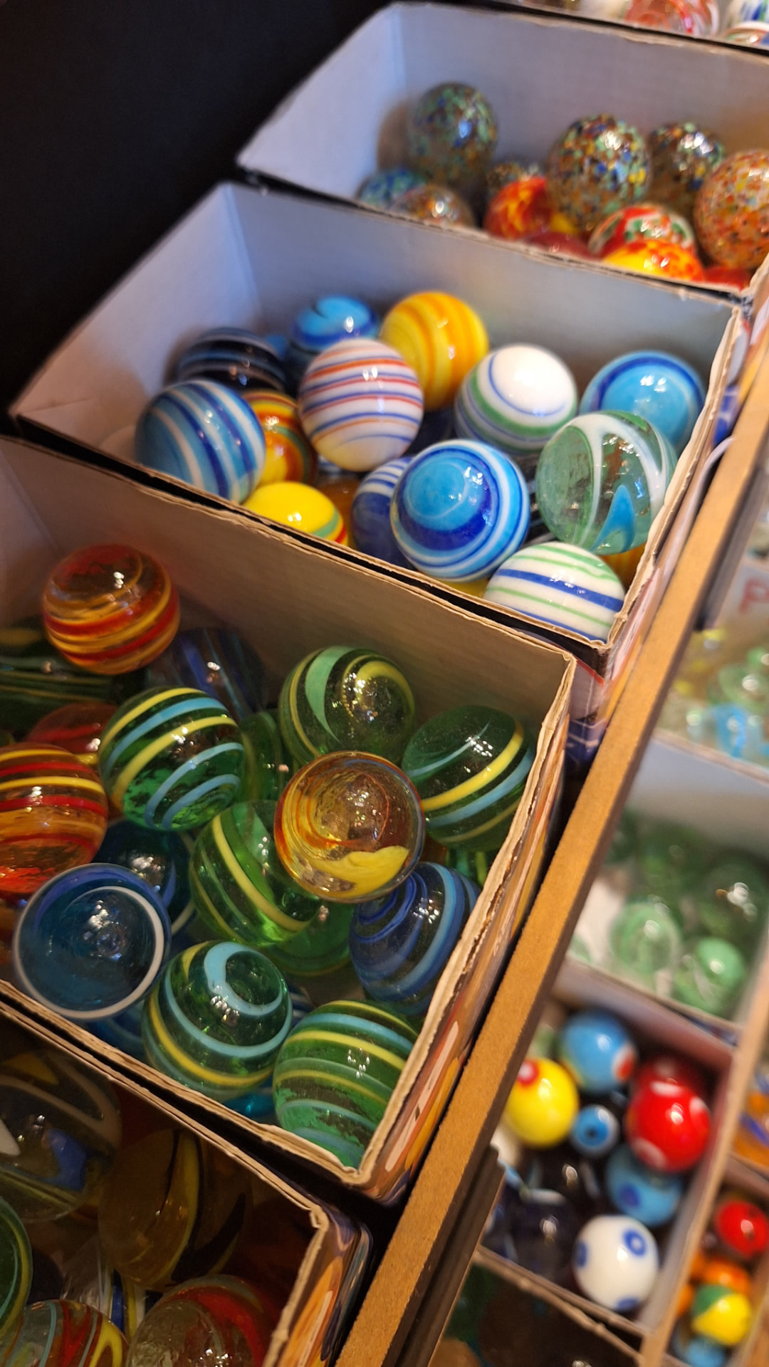 Billes en verre rayées et mouchetées dans leurs boîtes chez Luxiol