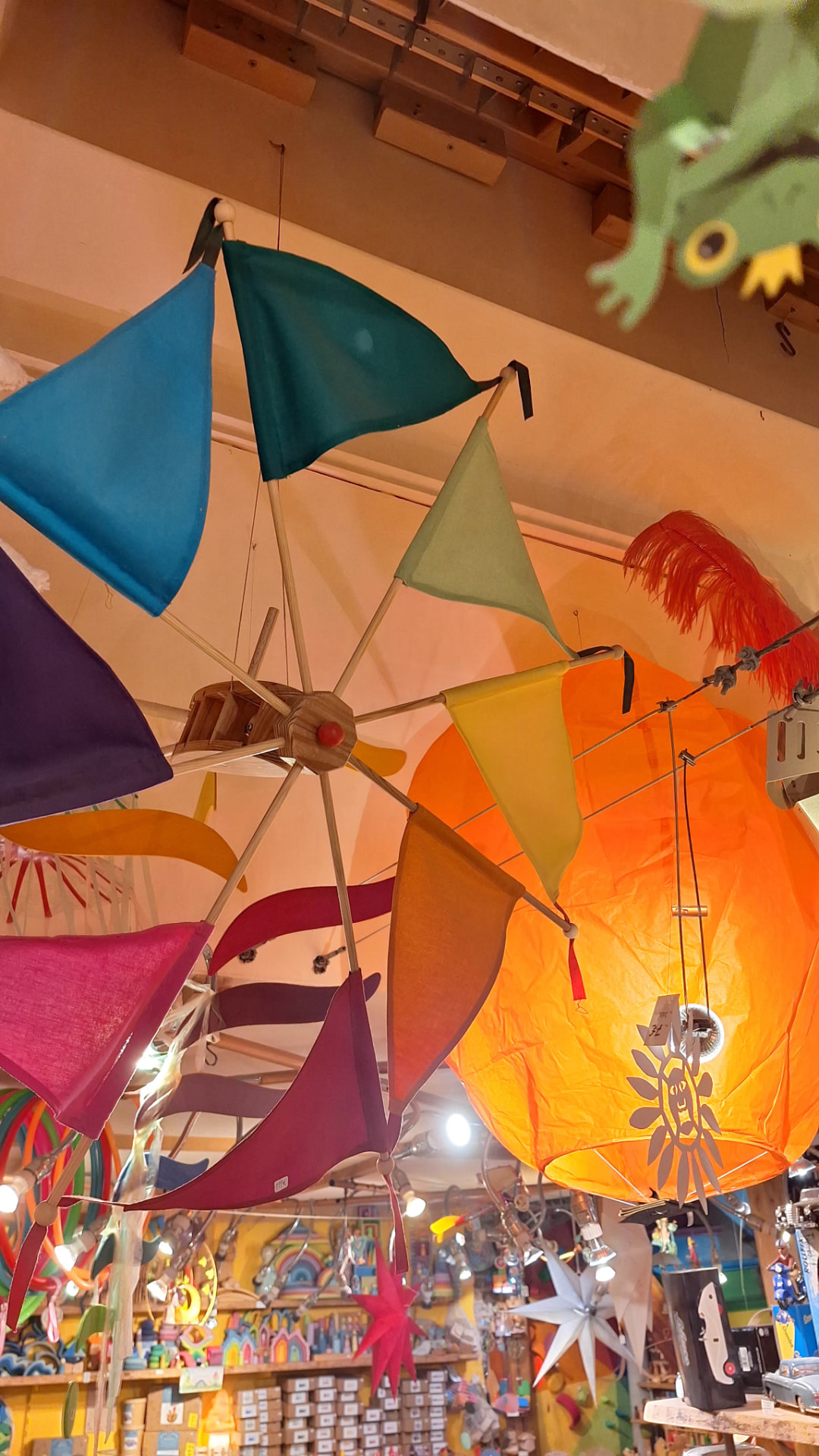 Moulin à vent en tissu multicolore et lanterne orange suspendus chez Luxiol