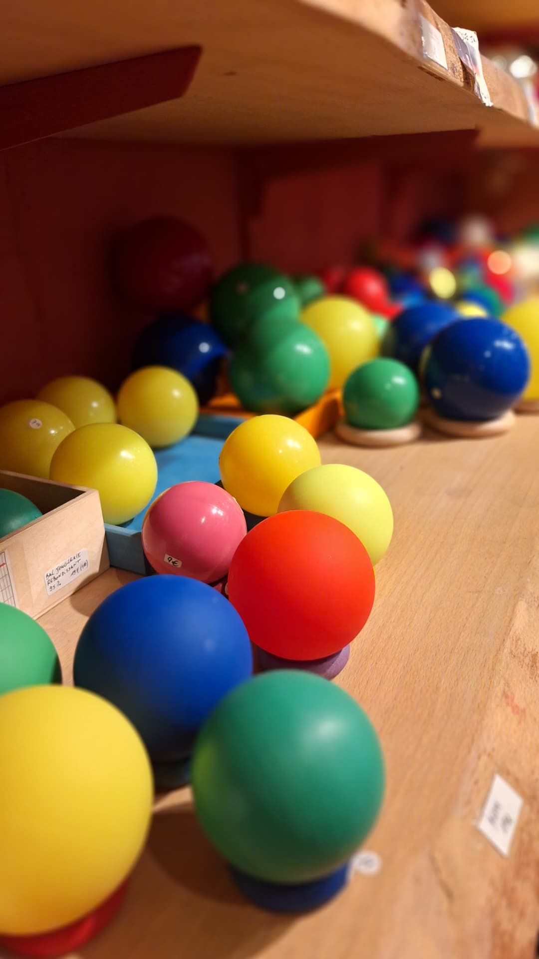 Balles de jonglerie colorées sur les étagères de Luxiol