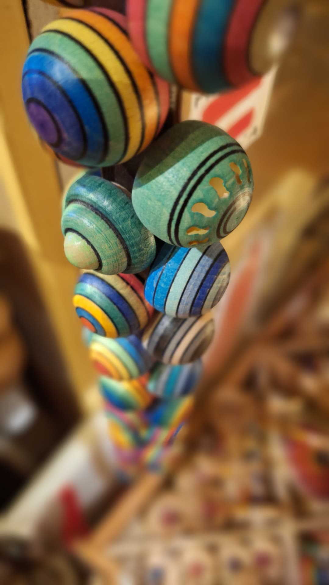 Toupies rayées multicolores suspendues en gros plan chez Luxiol