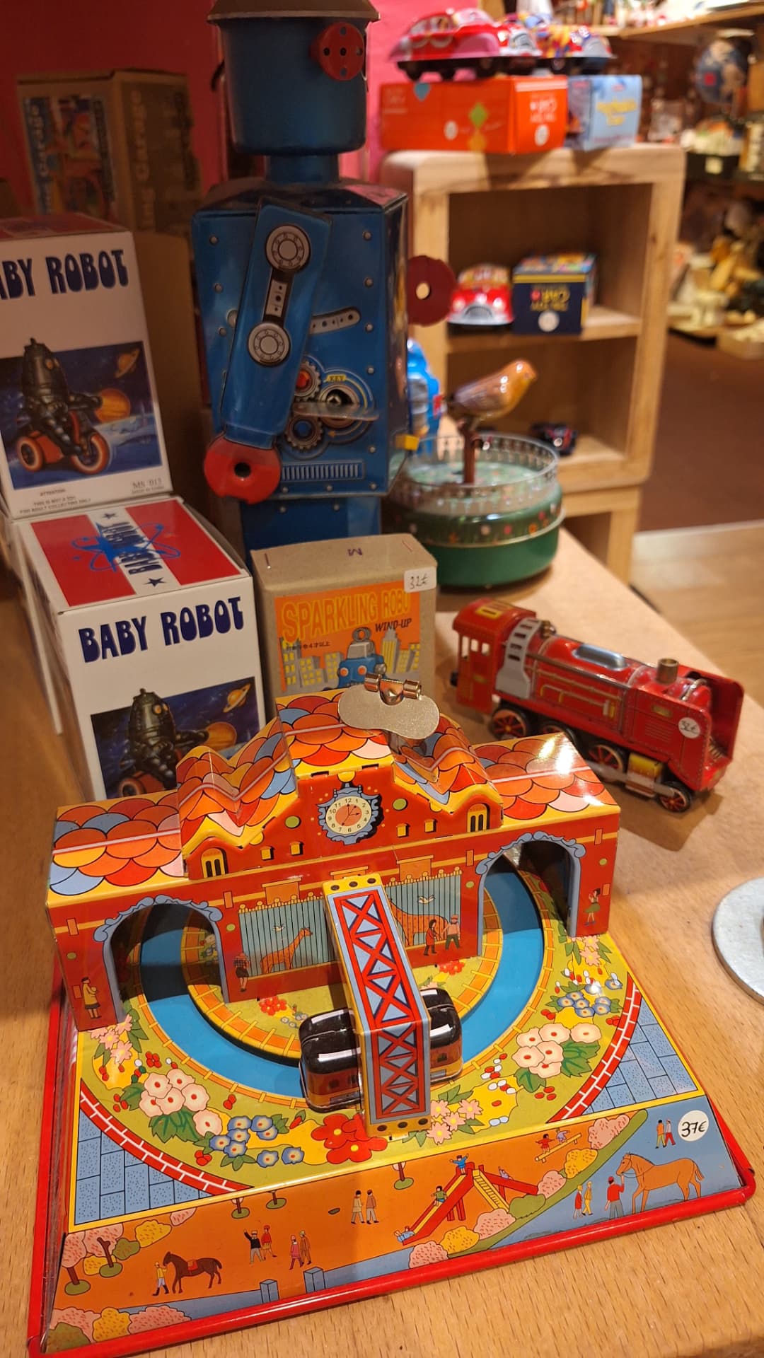 Robot en métal bleu, locomotive rouge et circuit en tôle chez Luxiol