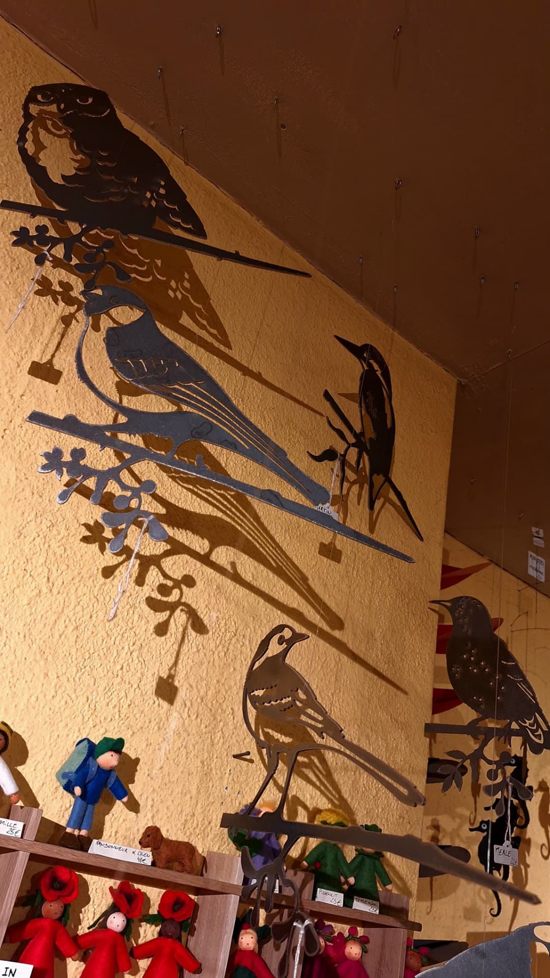 Silhouettes d'oiseaux en métal et leurs ombres sur le mur de Luxiol