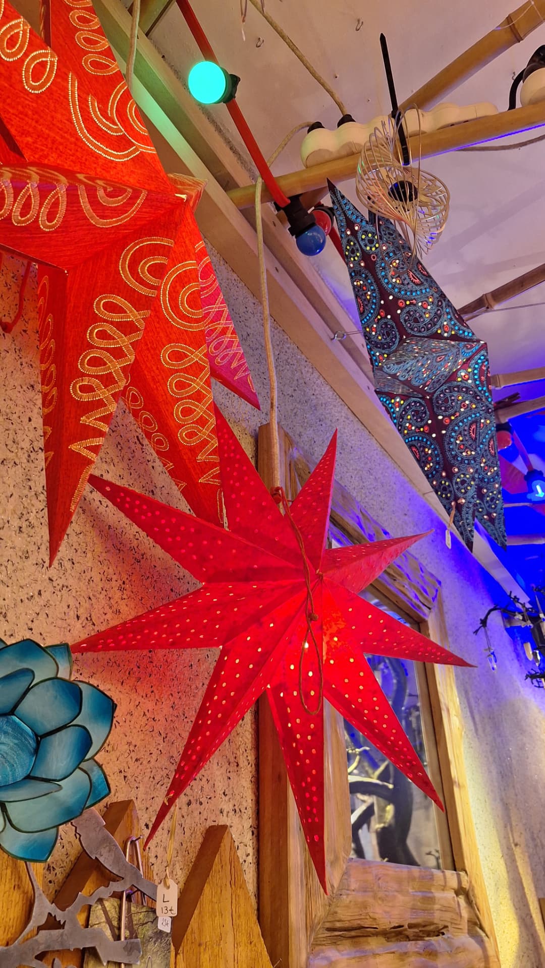 Étoiles en papier rouges et motifs colorés dans la vitrine de Luxiol