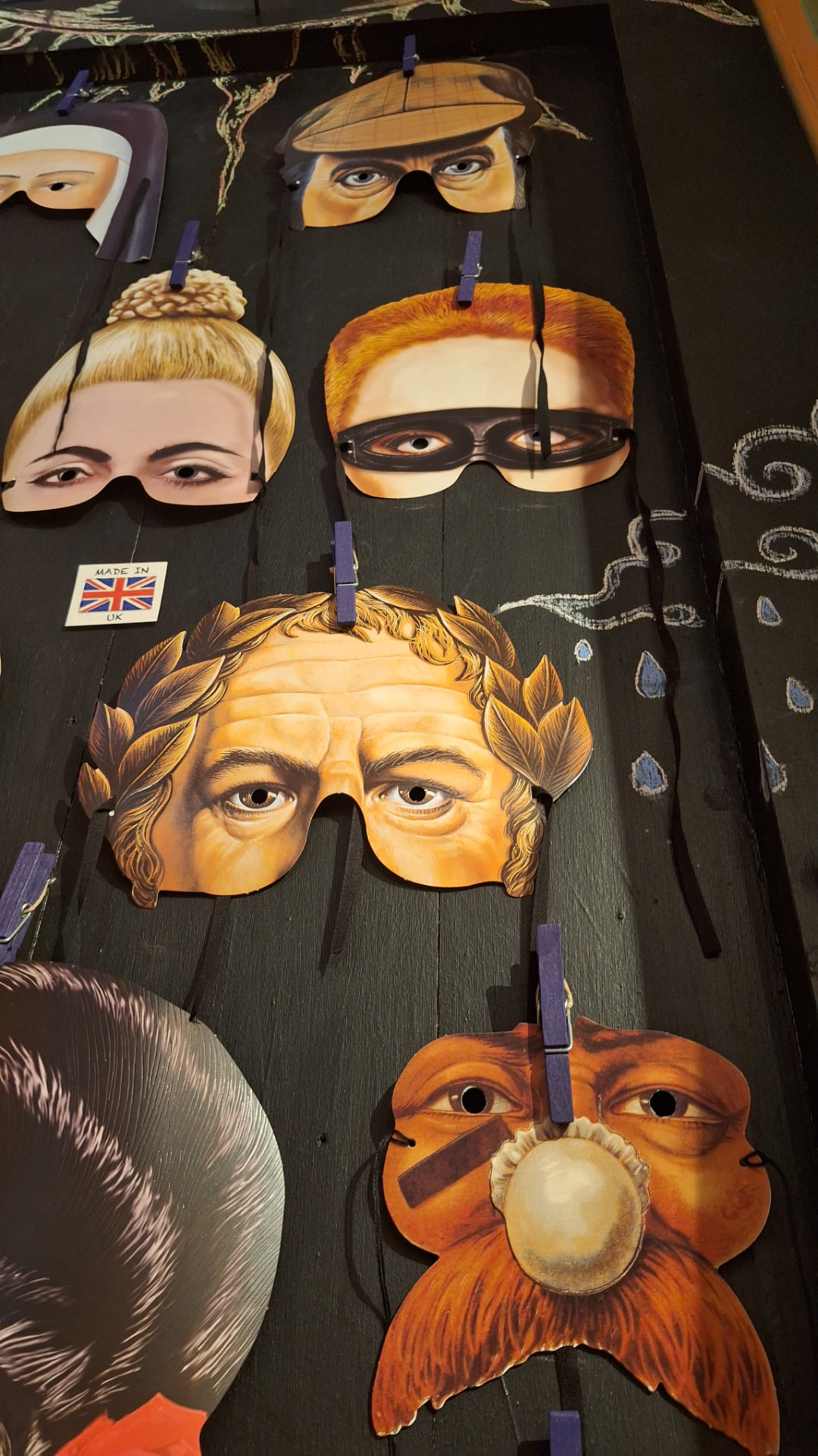 Masques accrochés sur la porte tableau noir de Luxiol