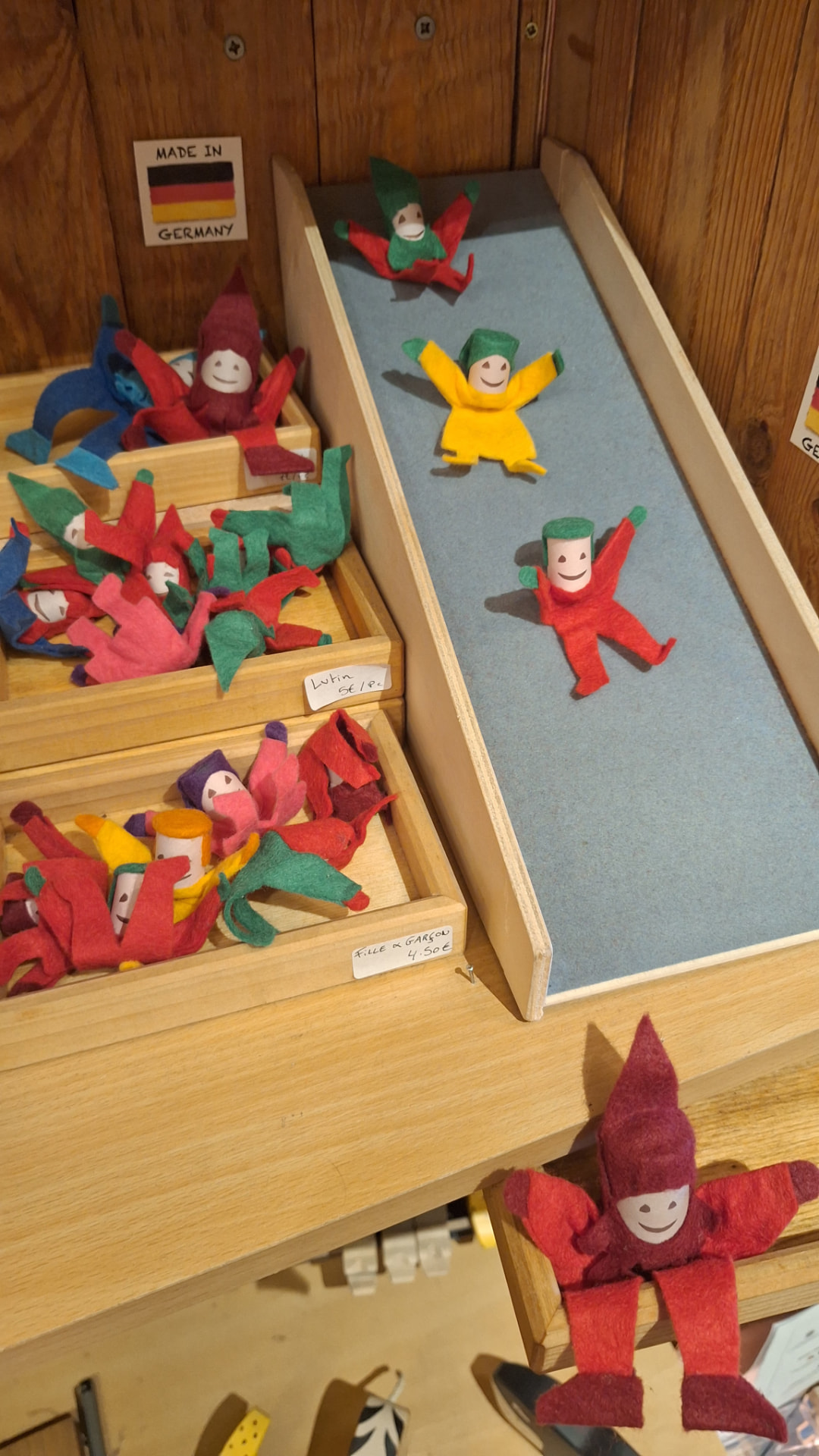 Petits lutins en feutrine descendant une glissoire en bois chez Luxiol