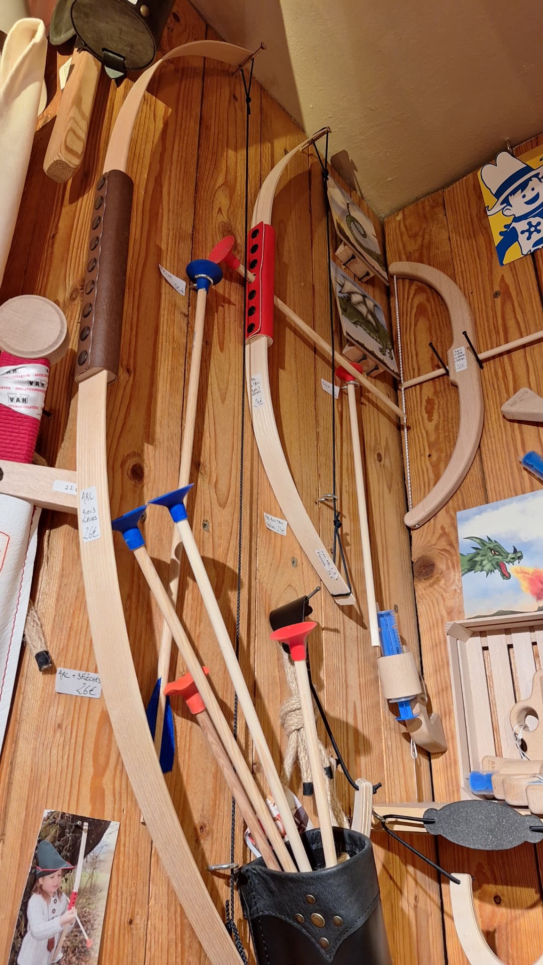 Arcs en bois et flèches à ventouse accrochés au mur chez Luxiol