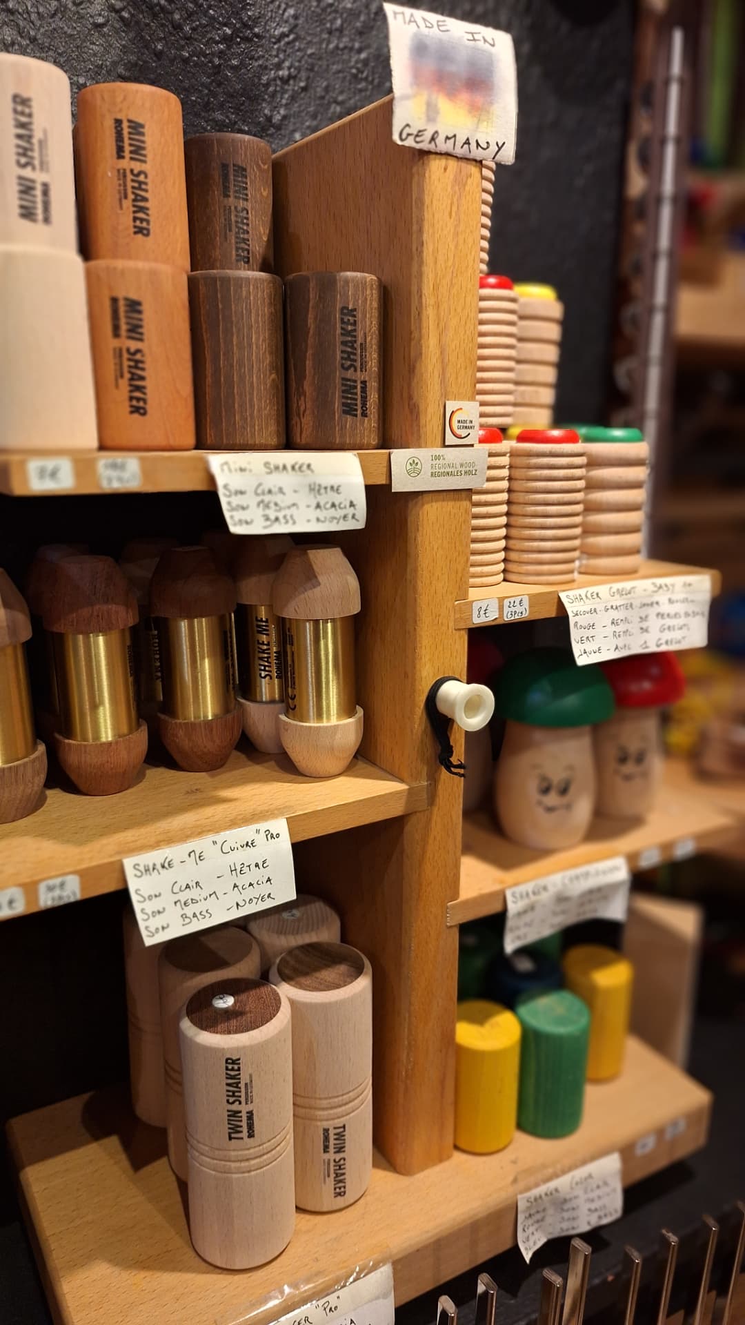 Shakers en bois et grelots colorés sur présentoir chez Luxiol