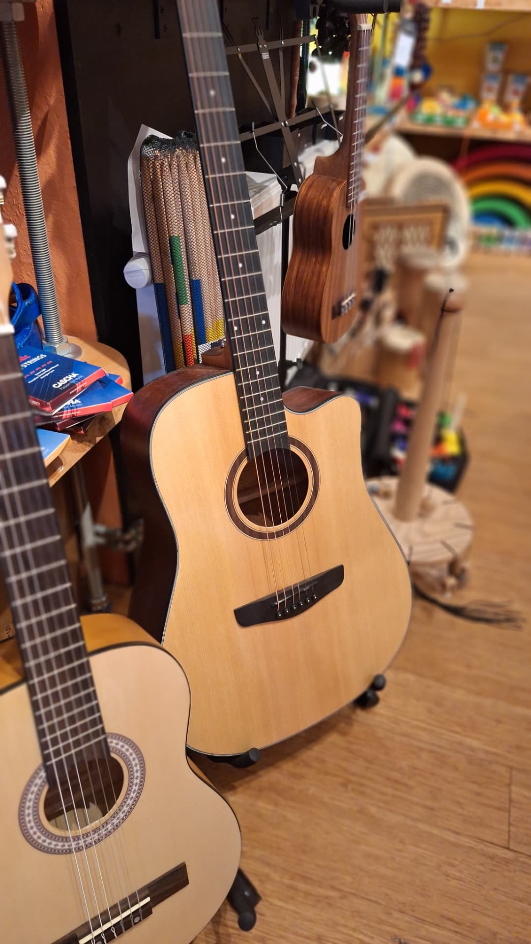 Guitares acoustiques et ukulélé suspendus chez Luxiol