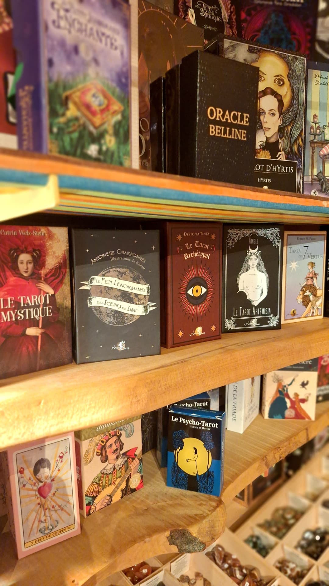Jeux de tarots et oracles illustrés sur étagères chez Luxiol