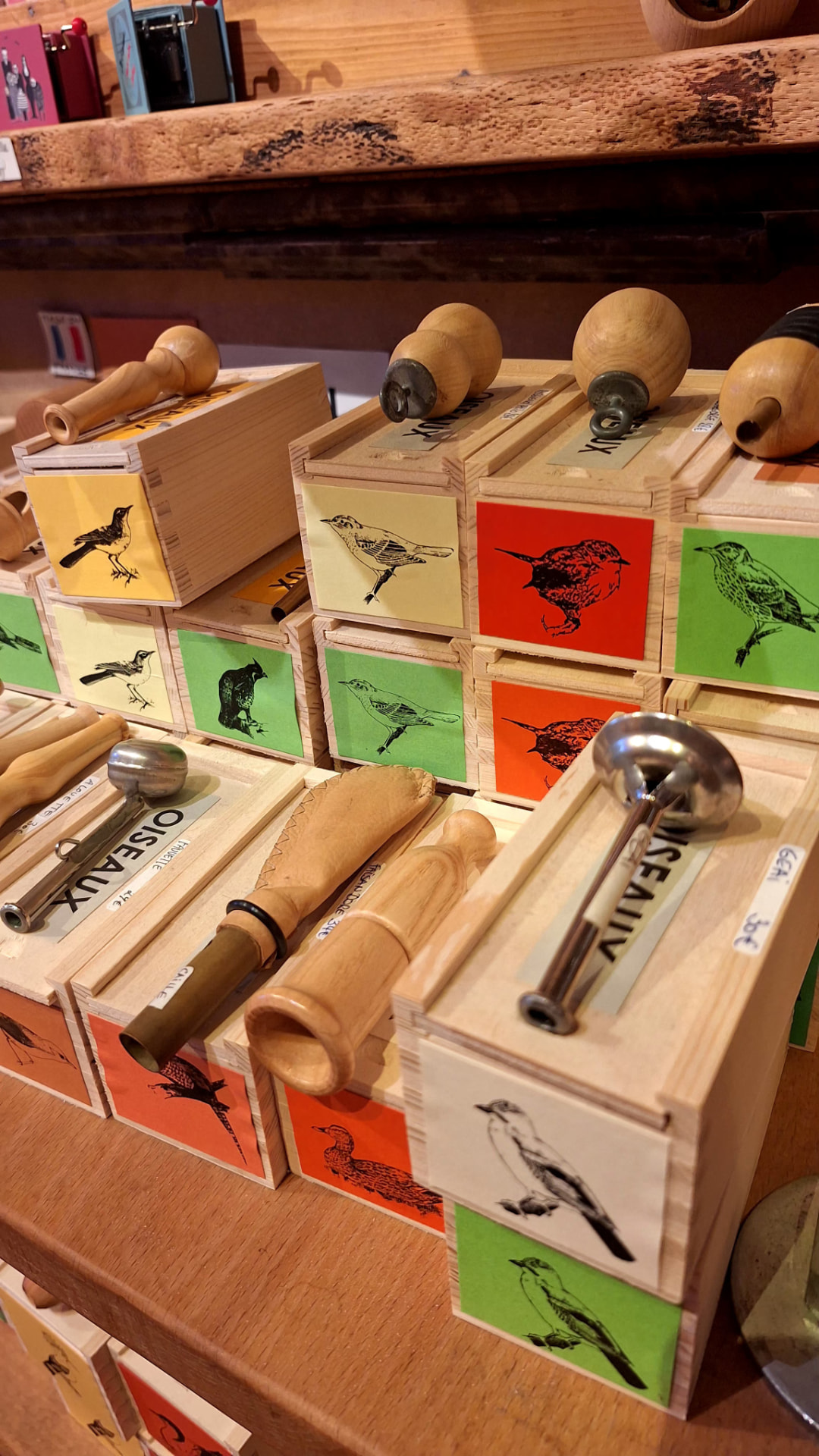 Appeaux en bois et métal posés sur leurs coffrets chez Luxiol