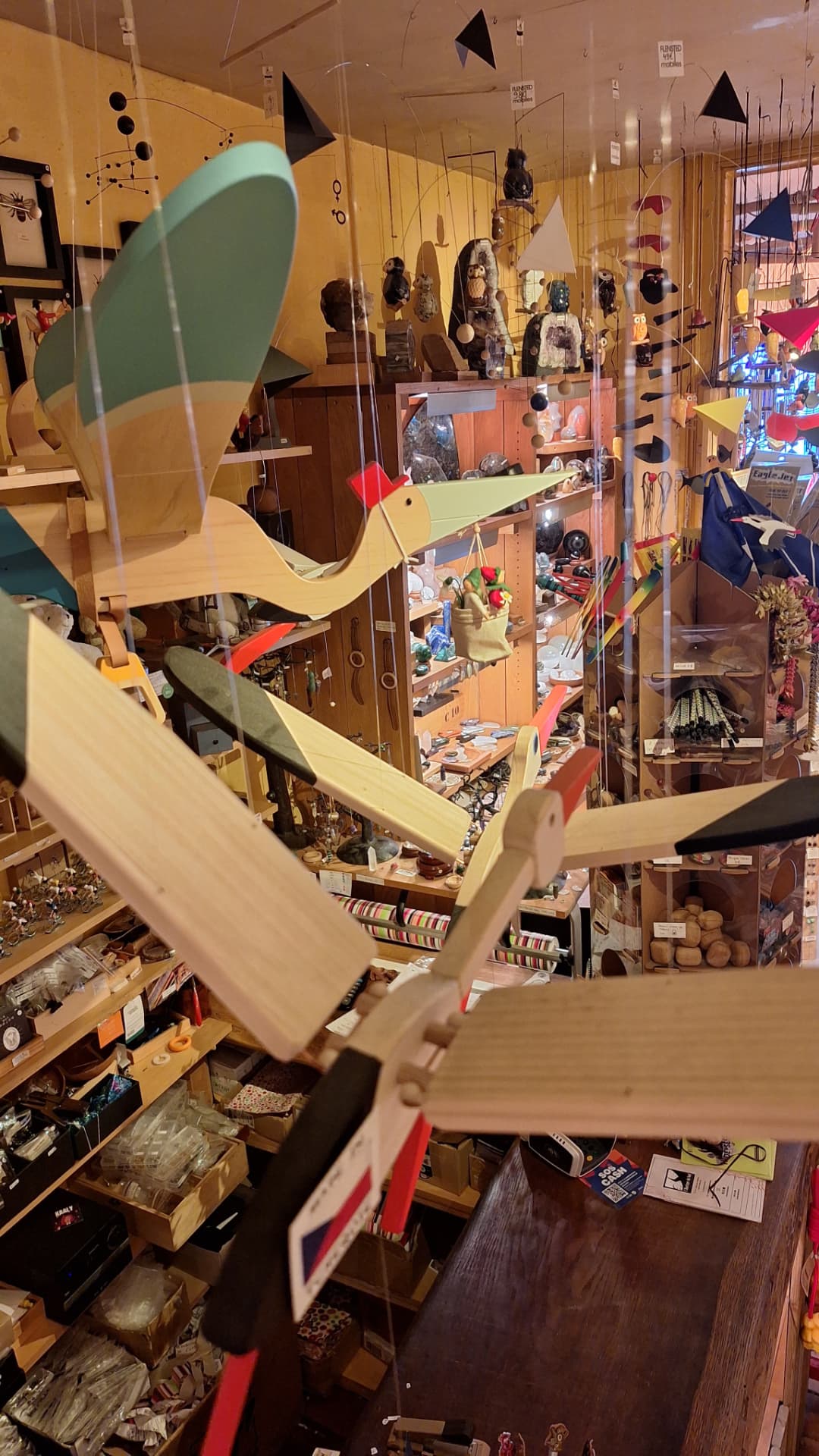 Mobiles en bois oiseaux et voiliers suspendus au-dessus de la boutique Luxiol