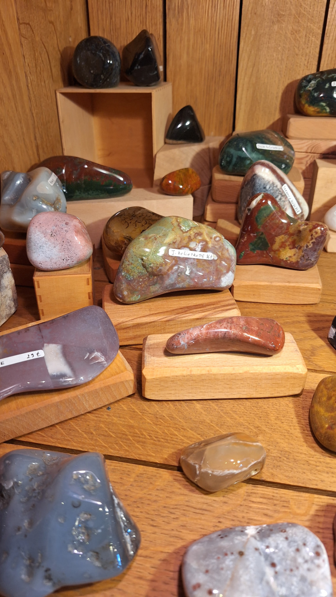 Pierres polies jaspe et agate présentées sur socles en bois chez Luxiol