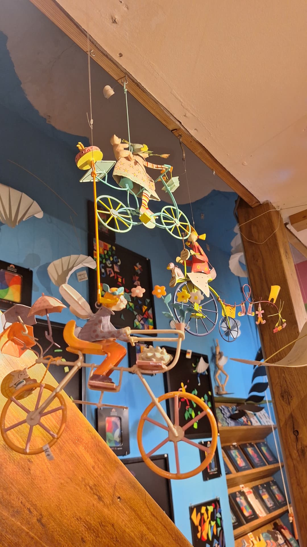 Mobiles métalliques de cyclistes colorés suspendus au plafond chez Luxiol