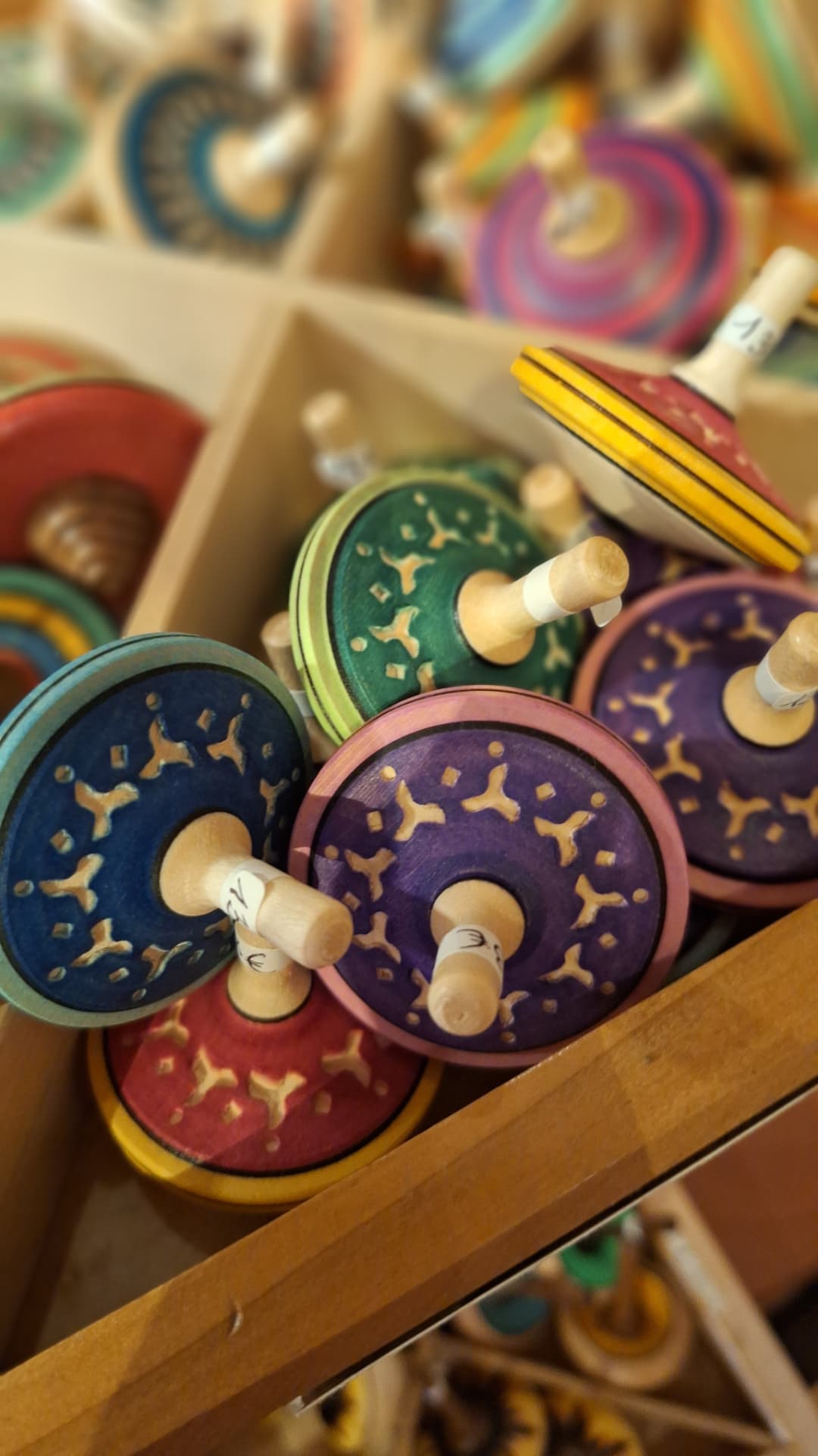 Toupies en bois sculptées et peintes en violet, bleu et vert chez Luxiol