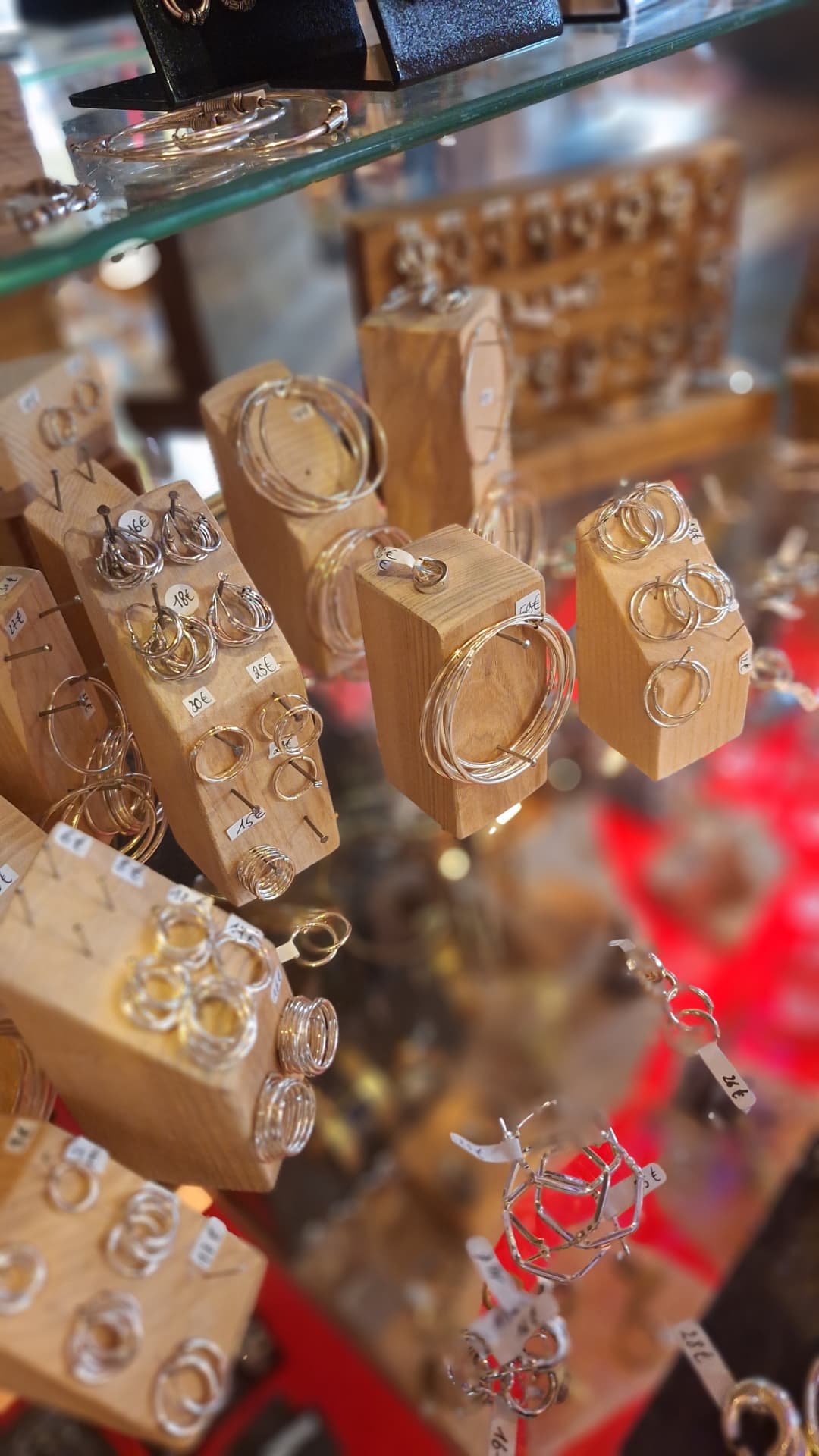 Créoles et anneaux en argent sur présentoirs en bois chez Luxiol