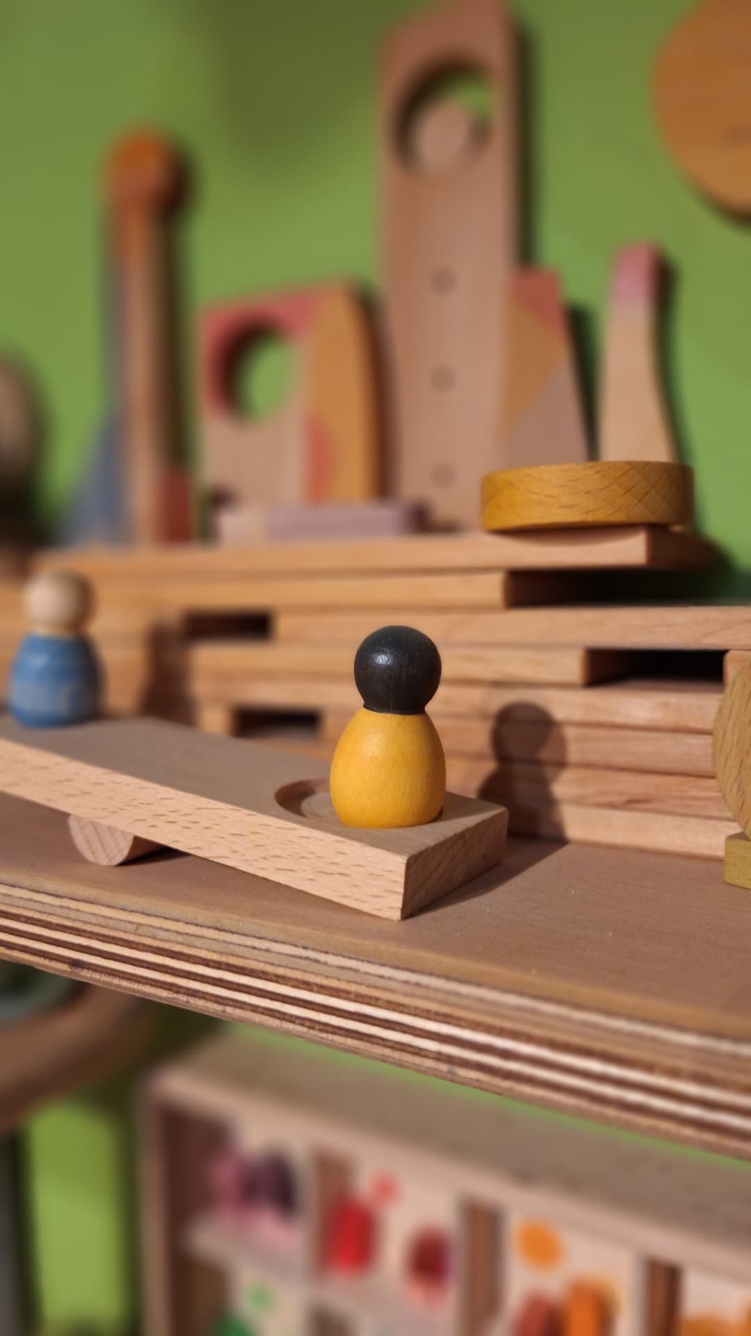 Petit personnage en bois sur une structure de jeu libre chez Luxiol