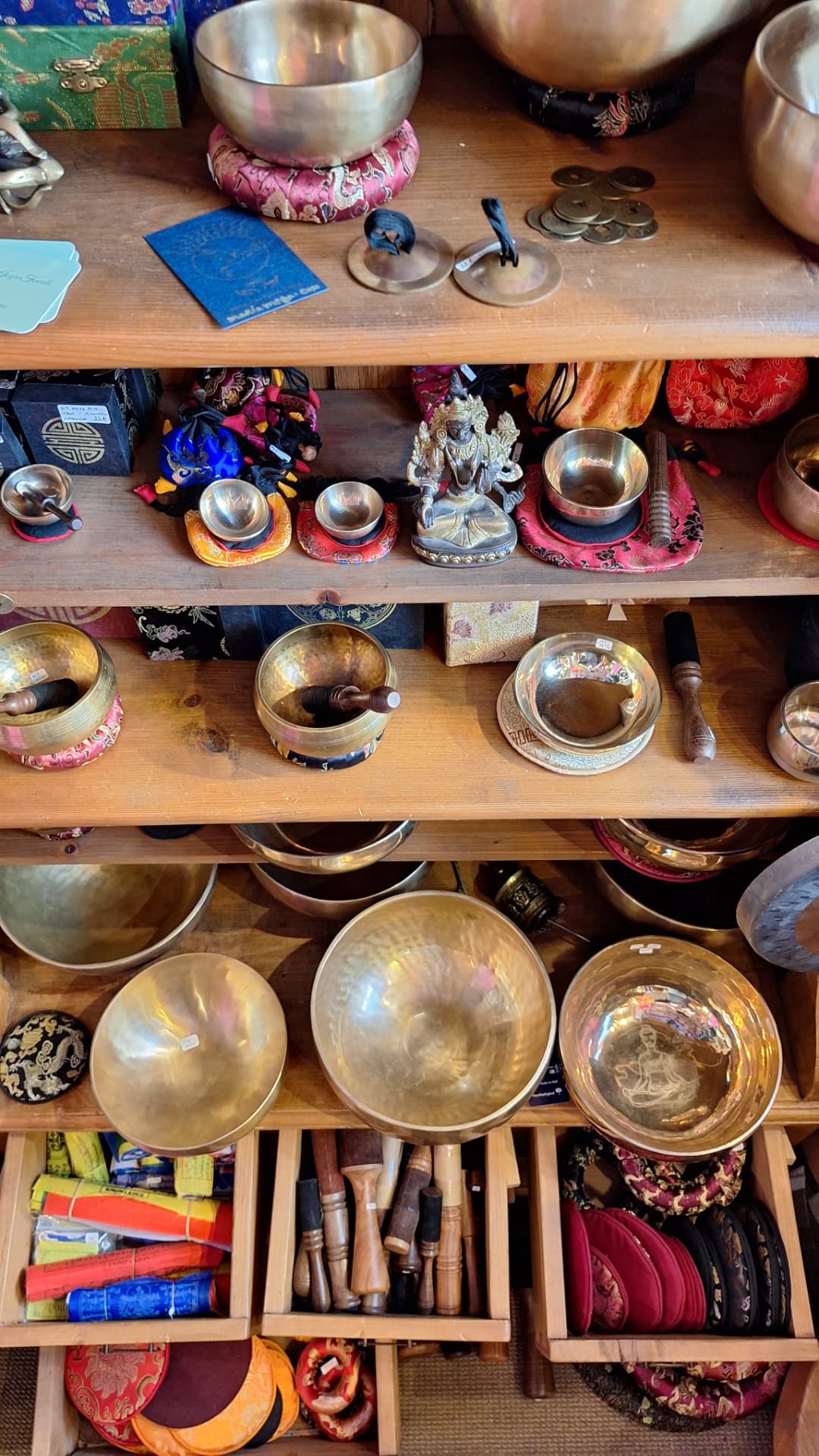 Étagères de bols tibétains, statuettes et cymbales chez Luxiol
