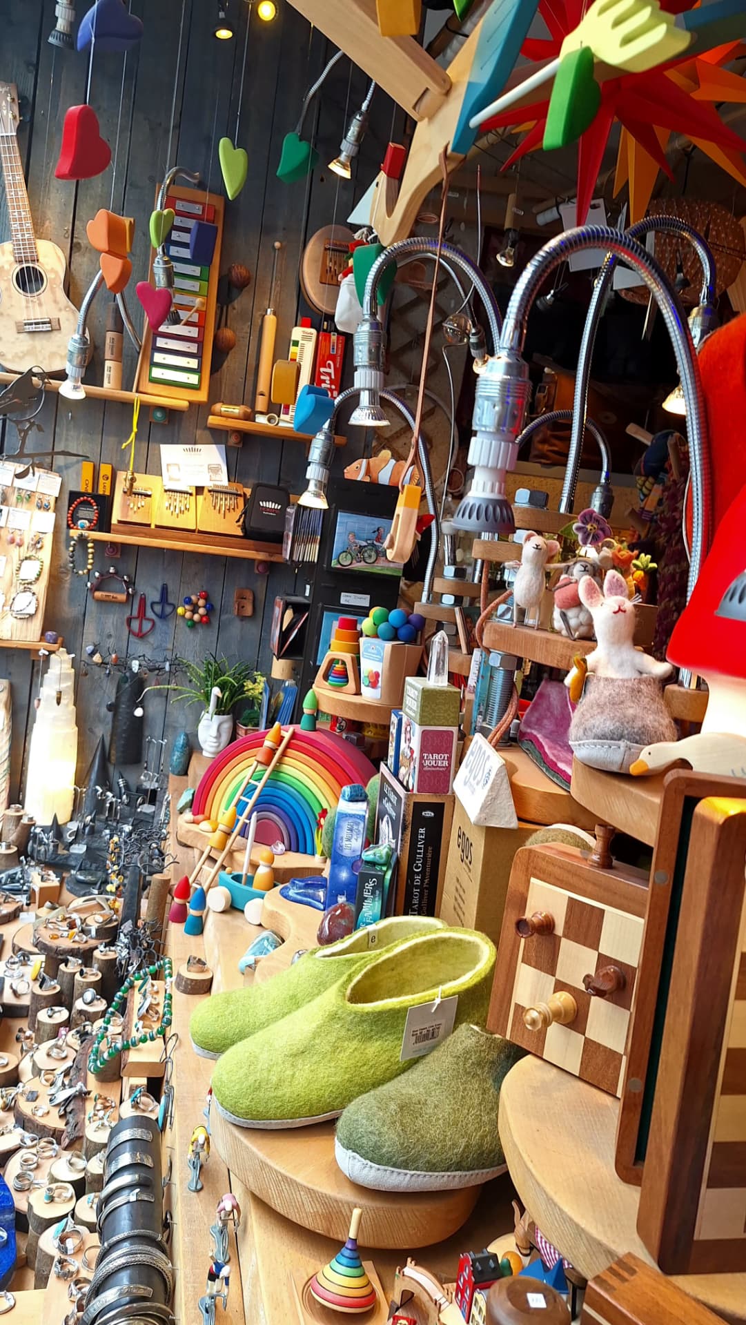 Intérieur de la vitrine Luxiol avec ukulélé, mobiles et chaussons verts