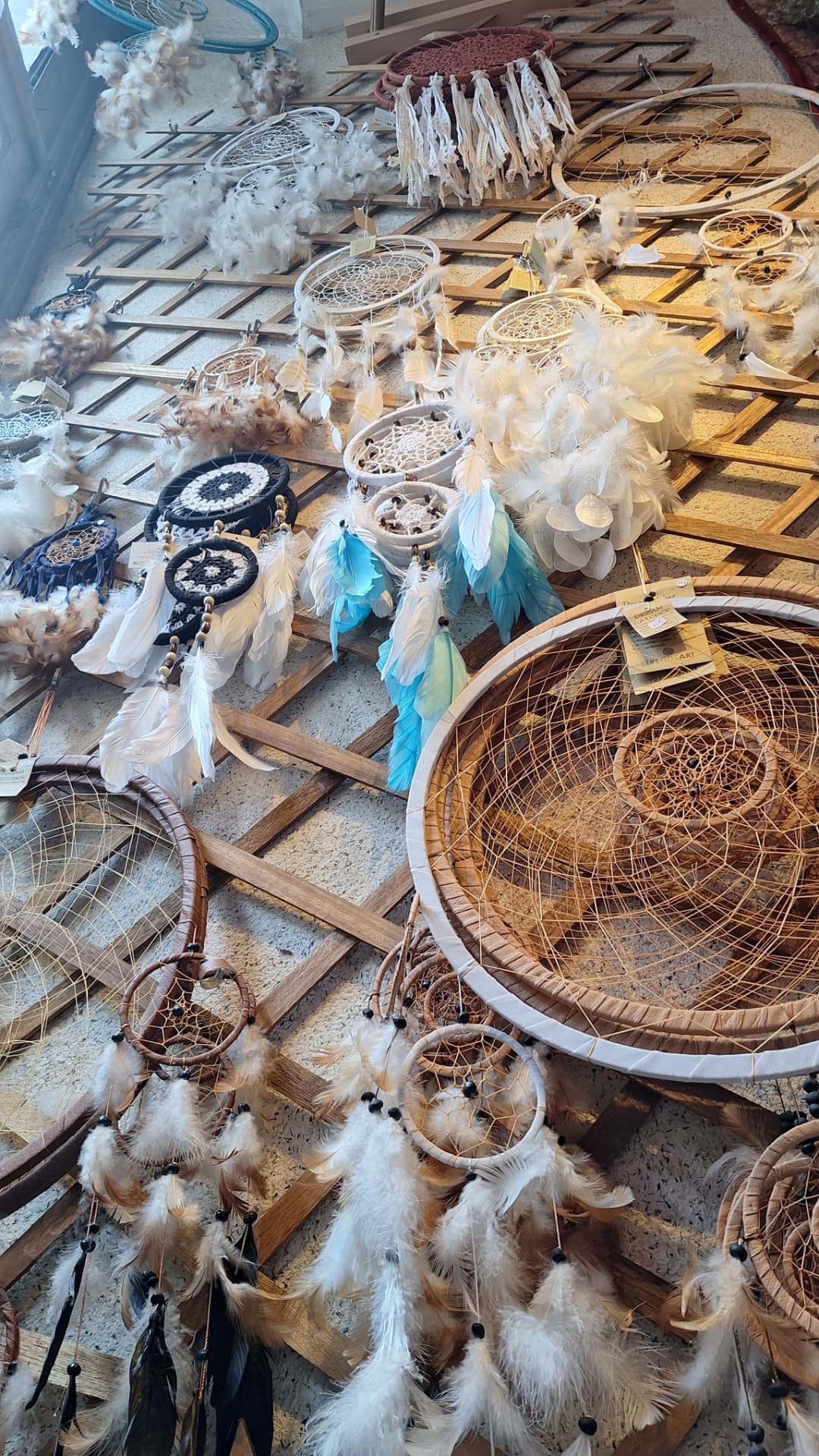 Attrape-rêves en plumes et rotin exposés en vitrine chez Luxiol